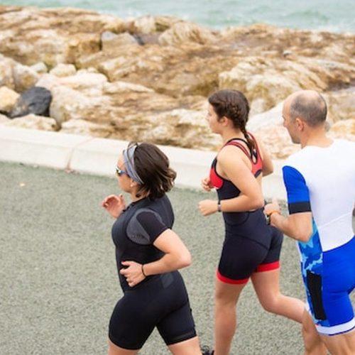 רצים מתאמנים לאורך קו החוף בפרוטארס עם נוף לים התיכון