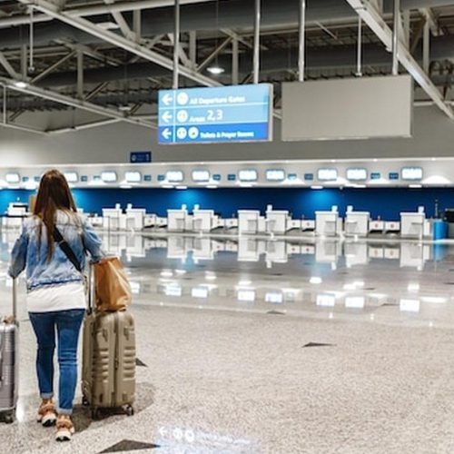 נוסעת עם מזוודות בדרך אל טרמינל היציאות, ממחישה יציאה מפרוטארס לשדה התעופה בלרנקה