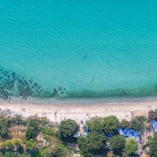 מבט על חוף וריסיאנה בפרוטארס - רצועת חול זהוב ומתרחצים במים הרדודים